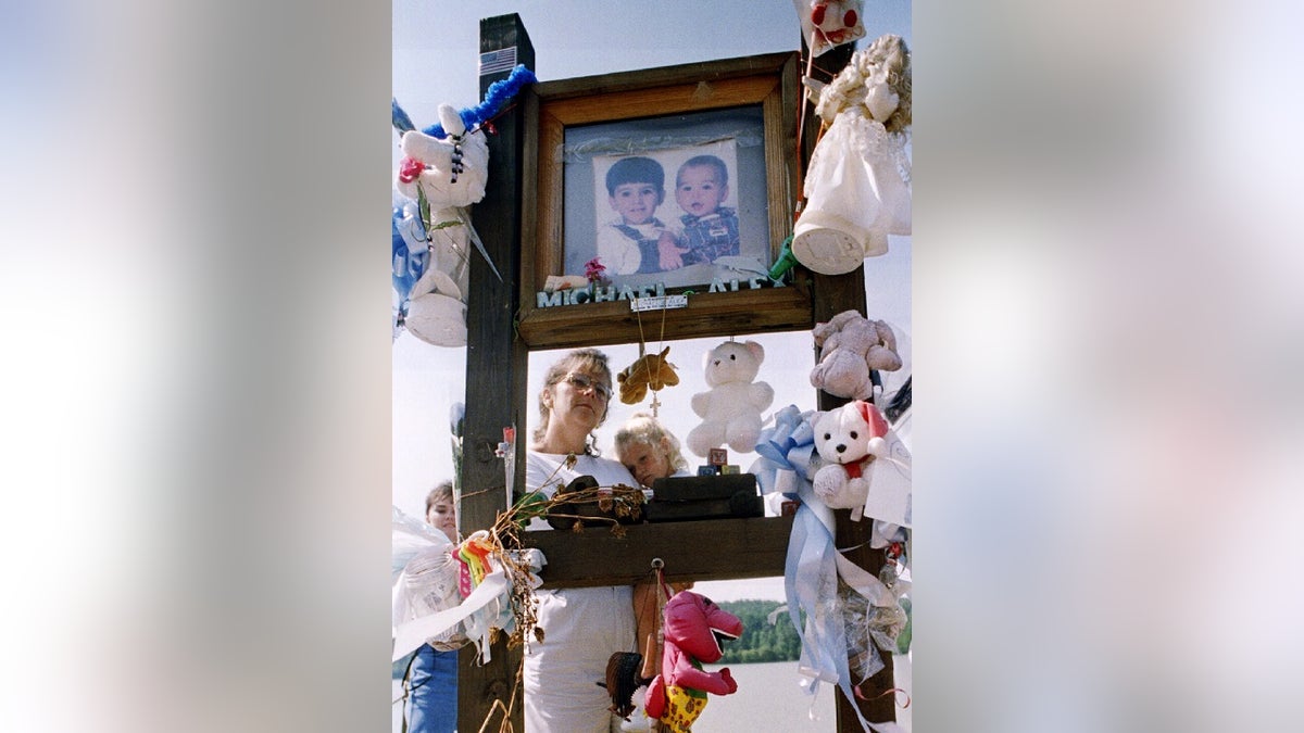 Shelby Hill reads a poem to her daughter Chelsea at the memorial to Alex and Michael Smith at John D. Long Lake near Union,S.C.