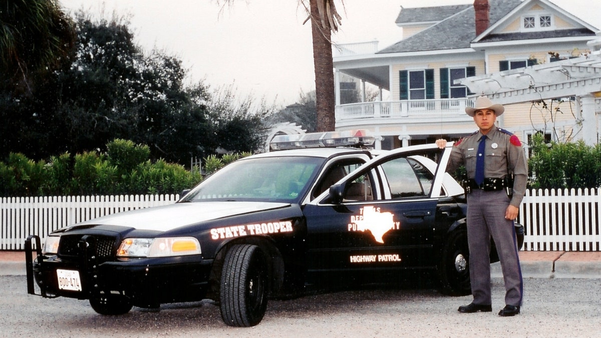 Former Texas state trooper Le Roy Torres with a patrol car