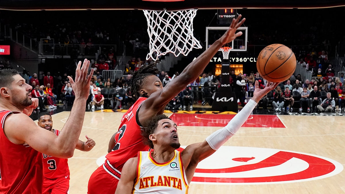 Atlanta Hawks guard Trae Young (11) has his shot blocked by Chicago Bulls Ayo Dosunmu (12) during the first half of an NBA basketball game Thursday, March 3, 2022, in Atlanta.