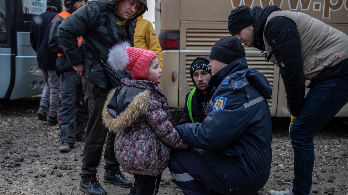 A local police officer helps a Ukrainian refugee girl who was apparently separated from her mother on March 09, 2022 at a reception centre near the Palanca border crossing on the Moldova- Ukraine border. (Siegfried Modola/ UNICEF)