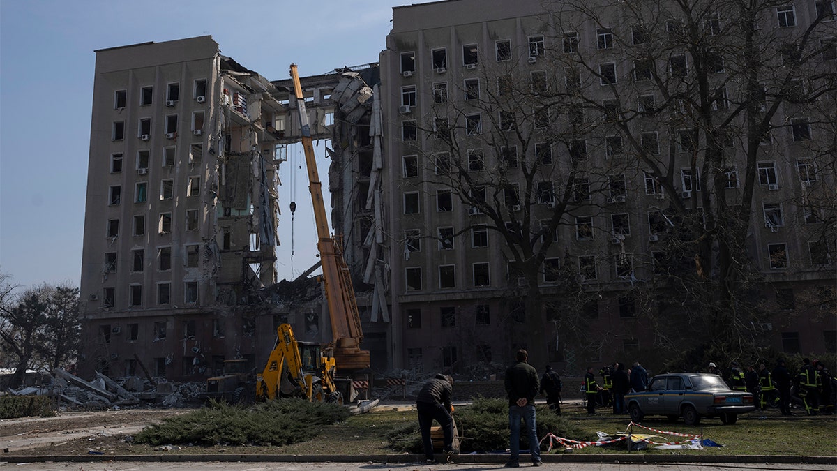 A crane operates at the regional government headquarters of Mykolaiv, Ukraine, after a Russian attack, on Wednesday, March 30, 2022. At least 15 people were killed in a missile strike on the regional government headquarters on Tuesday, March 29, in the southern city of Mykolayiv. (AP Photo/Petros Giannakouris)