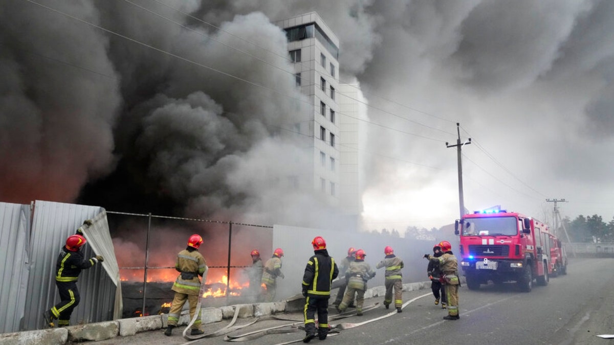 Firefighters work to extinguish a fire at a damaged logistic center after shelling in Kyiv, Ukraine, Thursday, March 3, 2022. Russian forces have escalated their attacks on crowded cities in what Ukraine's leader called a blatant campaign of terror. 