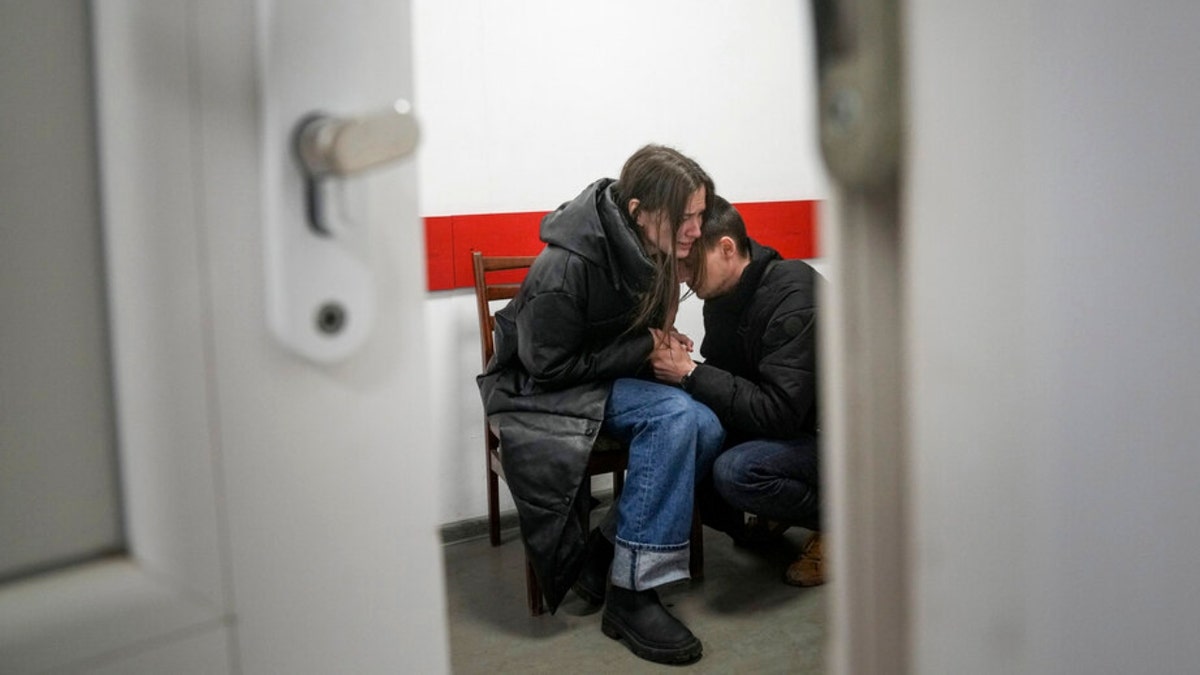 Marina Yatsko and her boyfriend Fedor comfort each other after her 18-month-old son Kirill was killed by shelling in a hospital in Mariupol, Ukraine, Friday, March 4, 2022. 