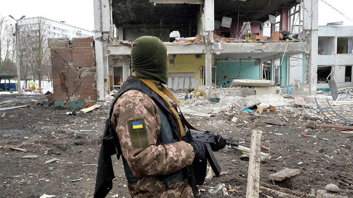 A member of the Ukrainian Territorial Defence Forces looks at destructions following a shelling in Ukraine's second-biggest city of Kharkiv on March 8, 2022.