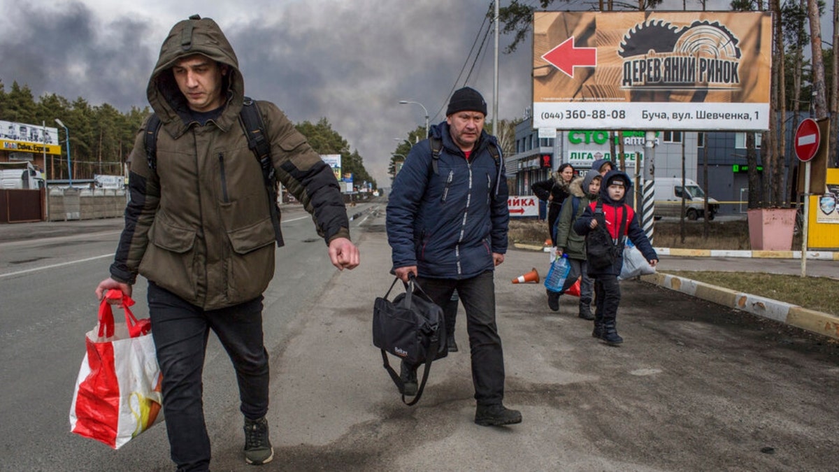 People leave the town of Bucha, close to Kyiv, Ukraine, Friday, March 4, 2022.
