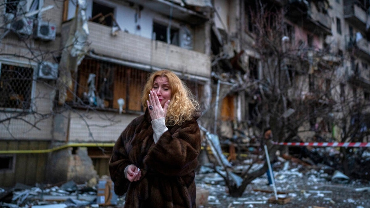Natali Sevriukova reacts next to her house following a rocket attack the city of Kyiv, Ukraine, Friday, Feb. 25, 2022.