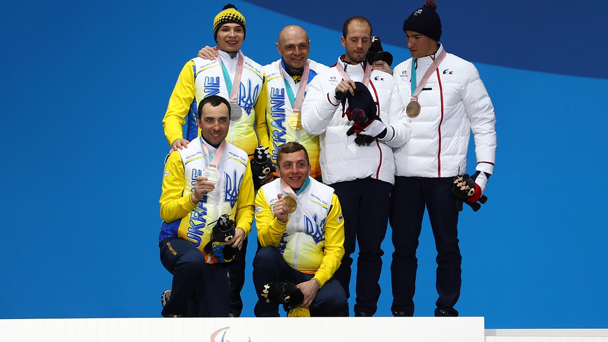 Silver medalist Oleksandr Kazik of Ukraine and his guide Sergiy Kucheryaviy, gold medalist Vitaliy Luk'yanenko of Ukraine and his guide Ivan Marchyshak, and bronze medalist Anthony Chalencon of France and his guide Simon Valverde celebrate during the medal ceremony for Men's 15 km Visually Impaired Biathlon on day eight of the PyeongChang 2018 Paralympic Games on March 17, 2018, in Pyeongchang-gun, South Korea.