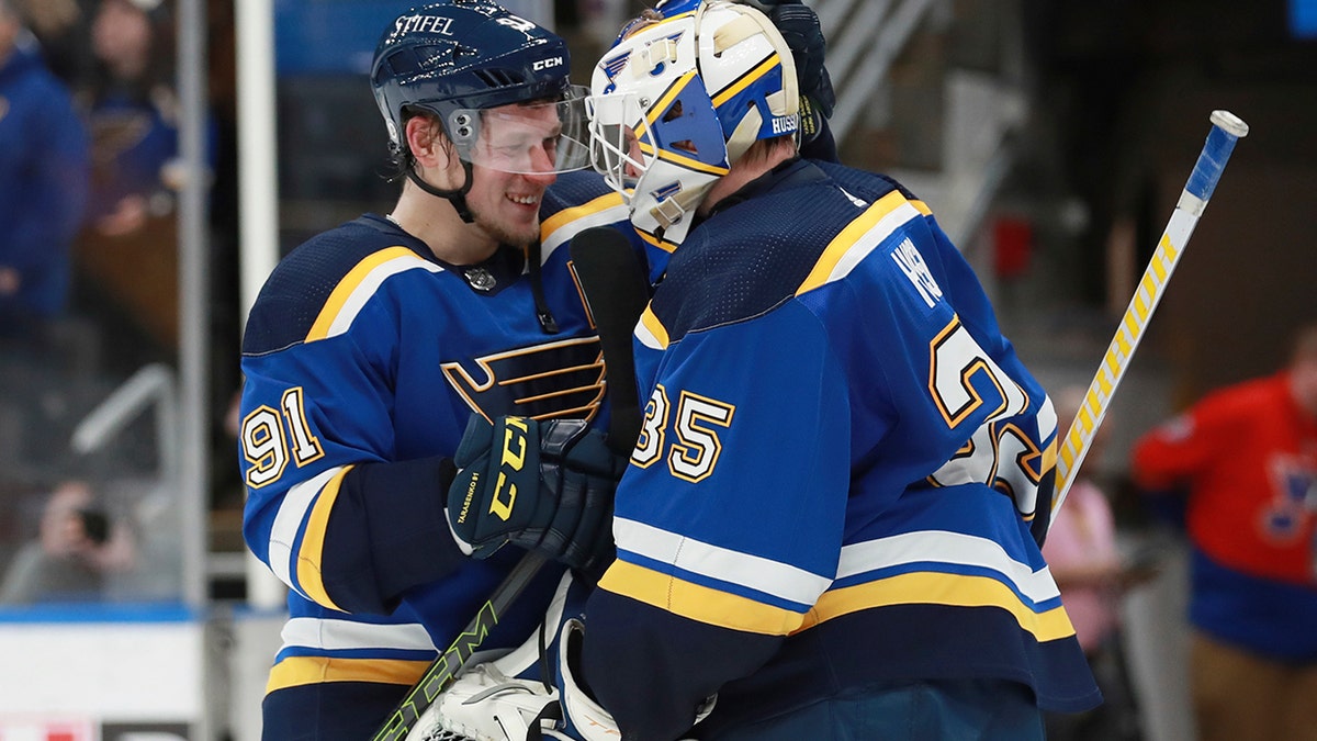 St. Louis Blues' Vladimir Tarasenko (91) and Ville Husso (35) celebrate after defeating the Vancouver Canucks in an NHL hockey game Monday, March 28, 2022, in St. Louis.