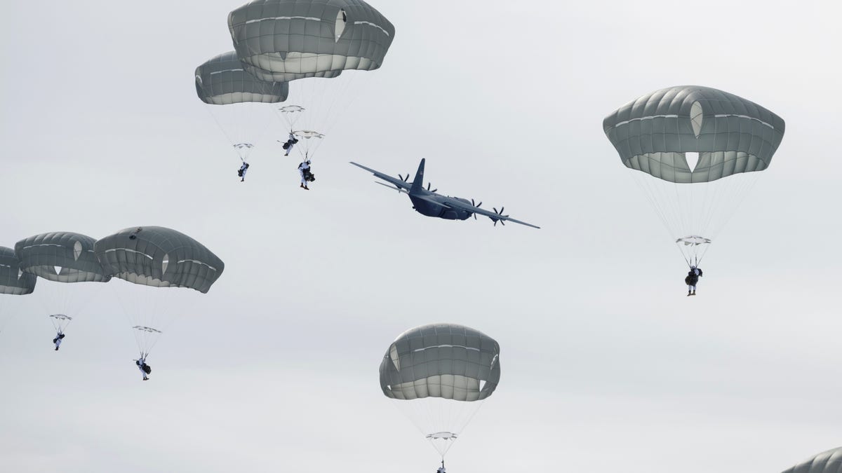 Army paratroopers jump from an Air Force C-130J Super Hercules during a simulated forced-entry parachute assault at Joint Base Elmendorf-Richardson, Alaska, March 31, 2021.