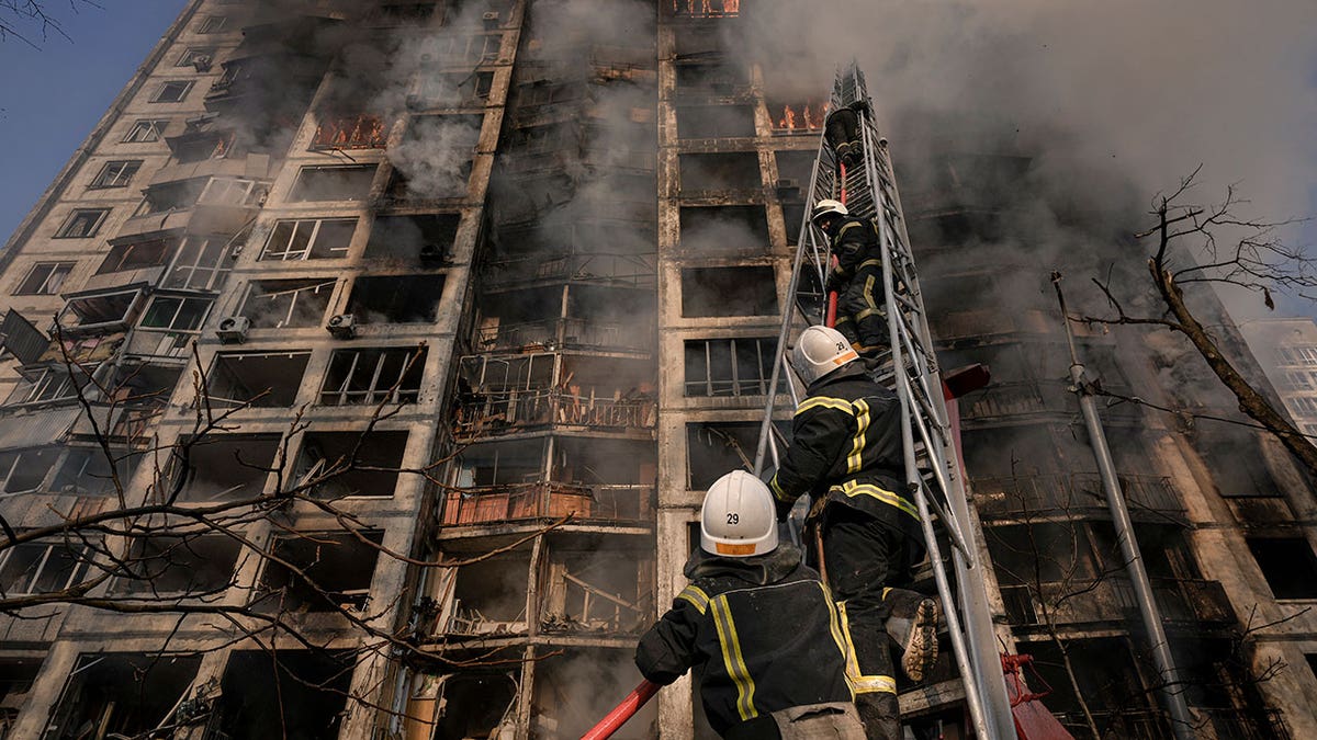 Firefighters climb a ladder while working to extinguish a blaze in a destroyed apartment building after a bombing in a residential area in Kyiv, Ukraine, Tuesday, March 15, 2022. Russia's offensive in Ukraine has edged closer to central Kyiv with a series of strikes hitting a residential neighborhood as the leaders of three European Union member countries planned a visit to Ukraine's embattled capital. (AP Photo/Vadim Ghirda)
