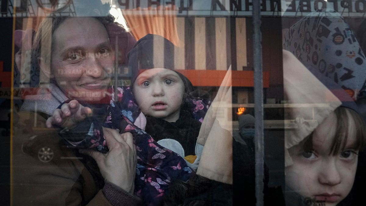 FILE - Internally displaced people look out from a bus at a refugee center in Zaporizhia, Ukraine, on March 25, 2022. The U.N. refugee agency says more than 4 million refugees have now fled Ukraine following Russia’s invasion, a new milestone in the largest refugee crisis in Europe since World War II. (AP Photo/Evgeniy Maloletka)