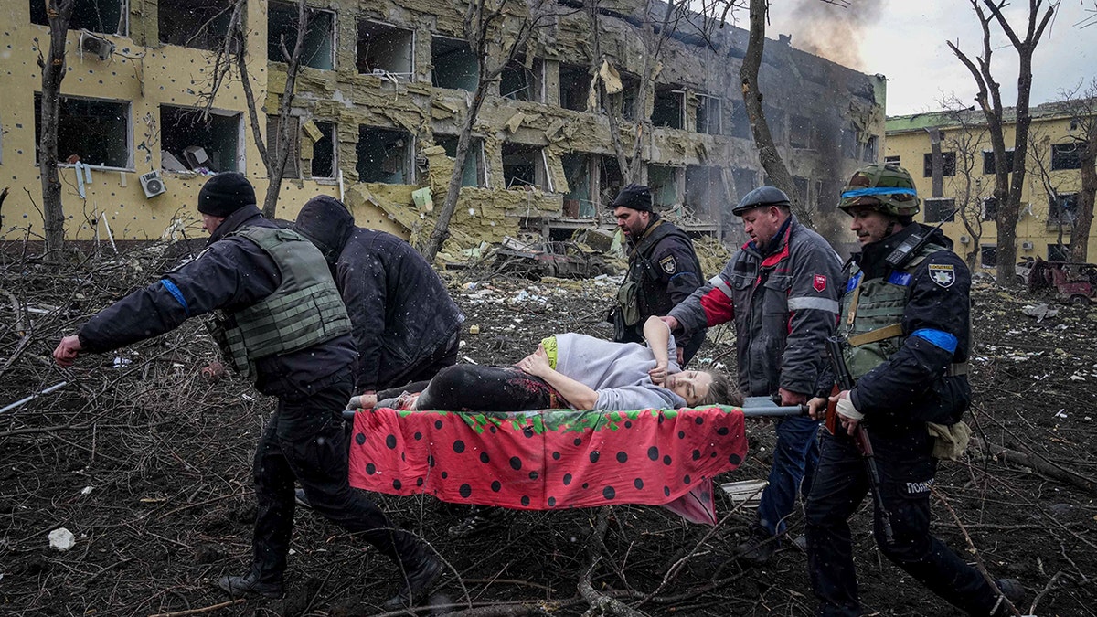 Ukrainian emergency employees and volunteers carry an injured pregnant woman from a maternity hospital damaged by shelling in Mariupol, Ukraine, Wednesday, March 9, 2022. The baby was born dead. Half an hour later, the mother died too. 
