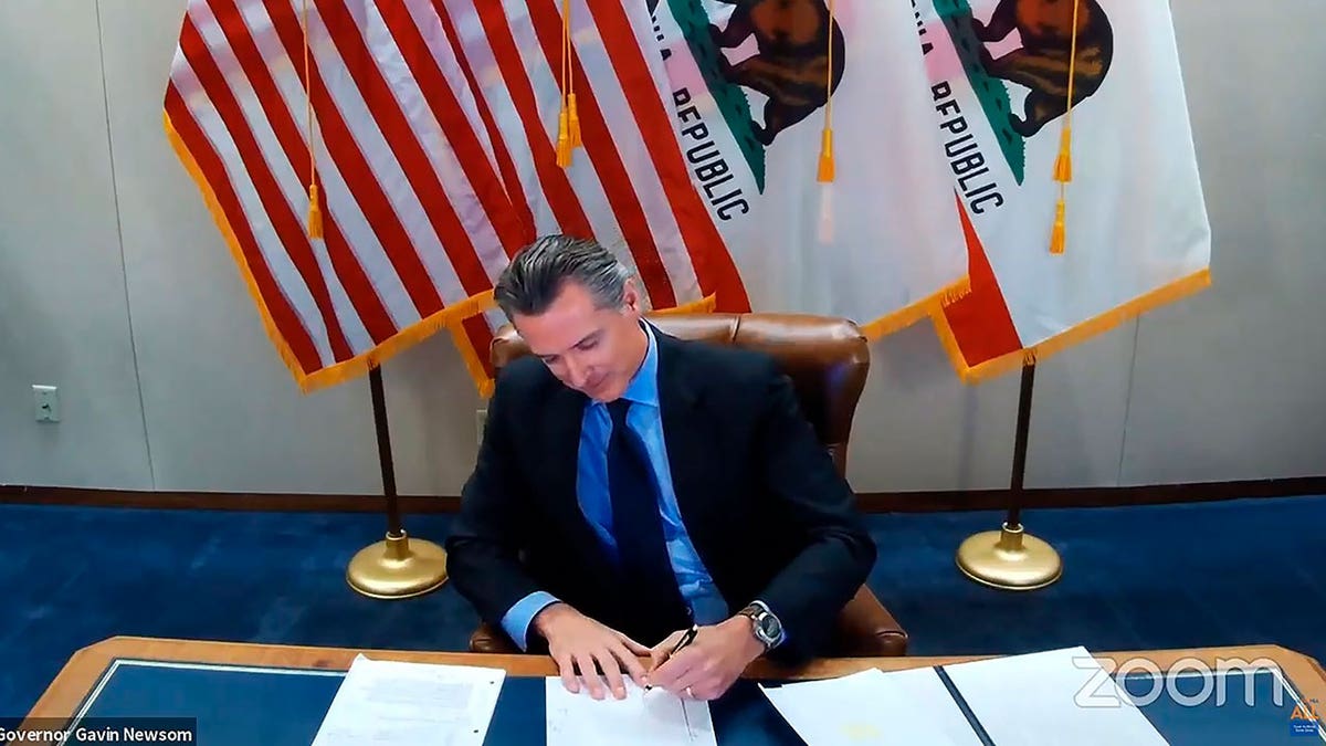 Gov. Gavin Newsom signs a bill establishing a task force to come up with recommendations on reparations for Black Americans, on Sept. 30, 2020, in Sacramento, California.