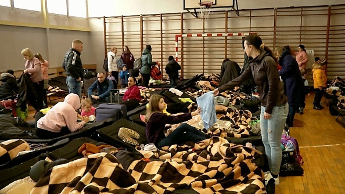 As streams of Ukrainian refugees pour into neighboring Poland, here some are housed in a gymnasium.