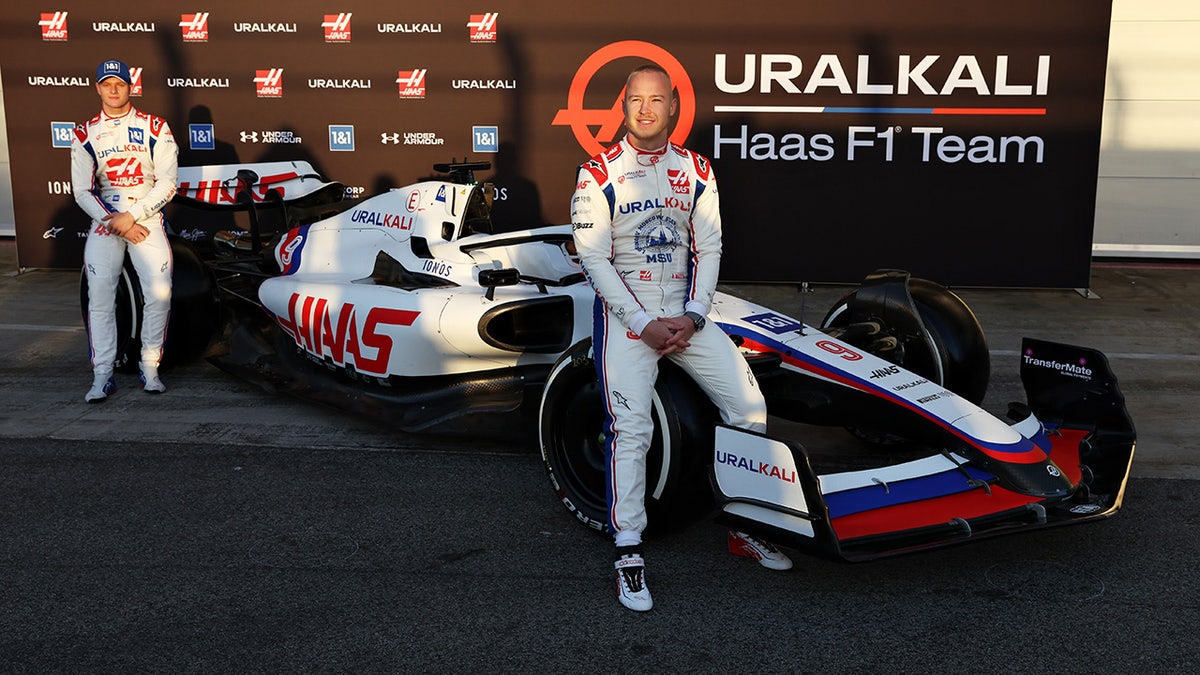 Russian Haas F1 driver Nikita Mazepin (R) was set to drive a car sponsored by his father's company Uralkali that wore the colors of the Russian flag this season.