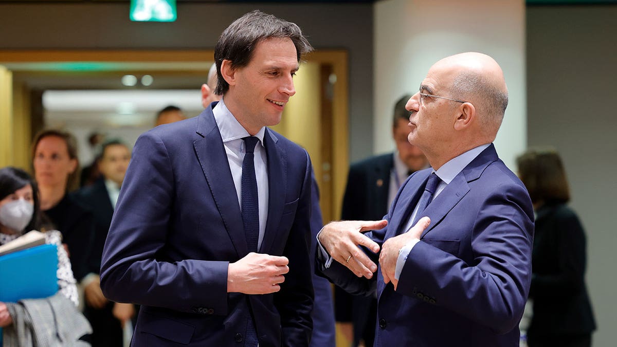 Dutch Foreign Minister Wopke Hoekstra, left, speaks with Greek Foreign Minister Nikos Dendias during a meeting of the EU foreign ministers at the Europa building in Brussels, Monday, March 21, 2022.