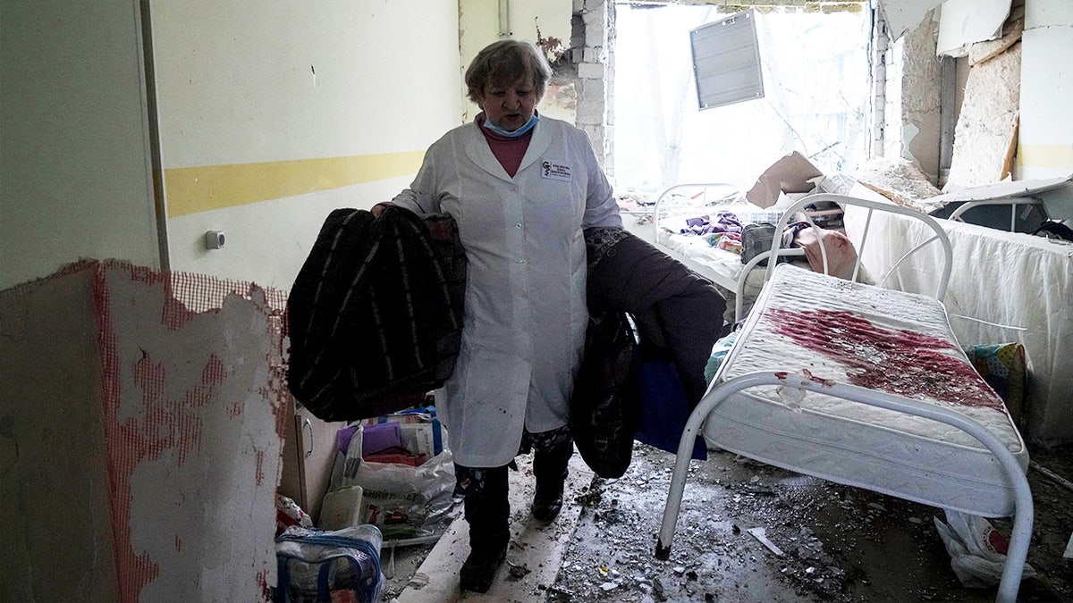 A medical worker walks inside a maternity hospital in Mariupol, Ukraine, damaged by shelling 