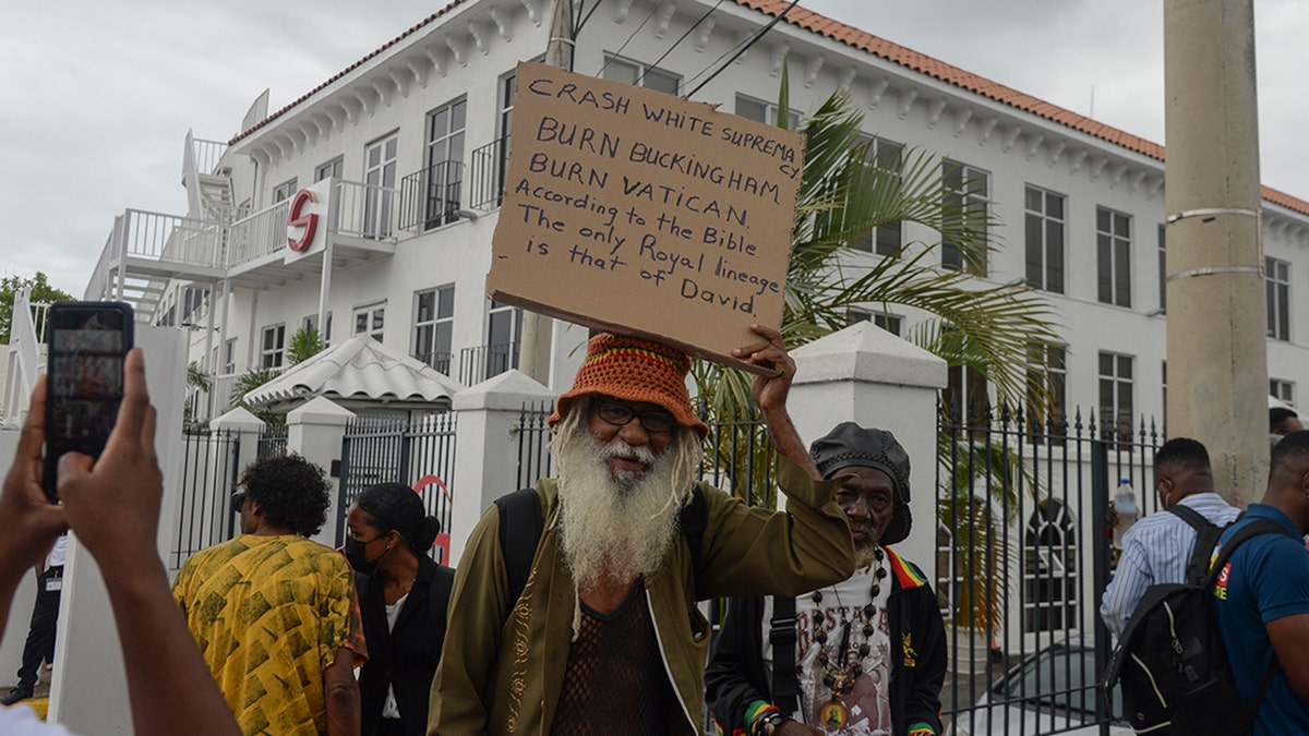 People protest to demand an apology and slavery reparations during a visit to the former British colony by the Duke and Duchess of Cambridge, Prince William and Kate, in Kingston, Jamaica, Tuesday, March 22, 2022.