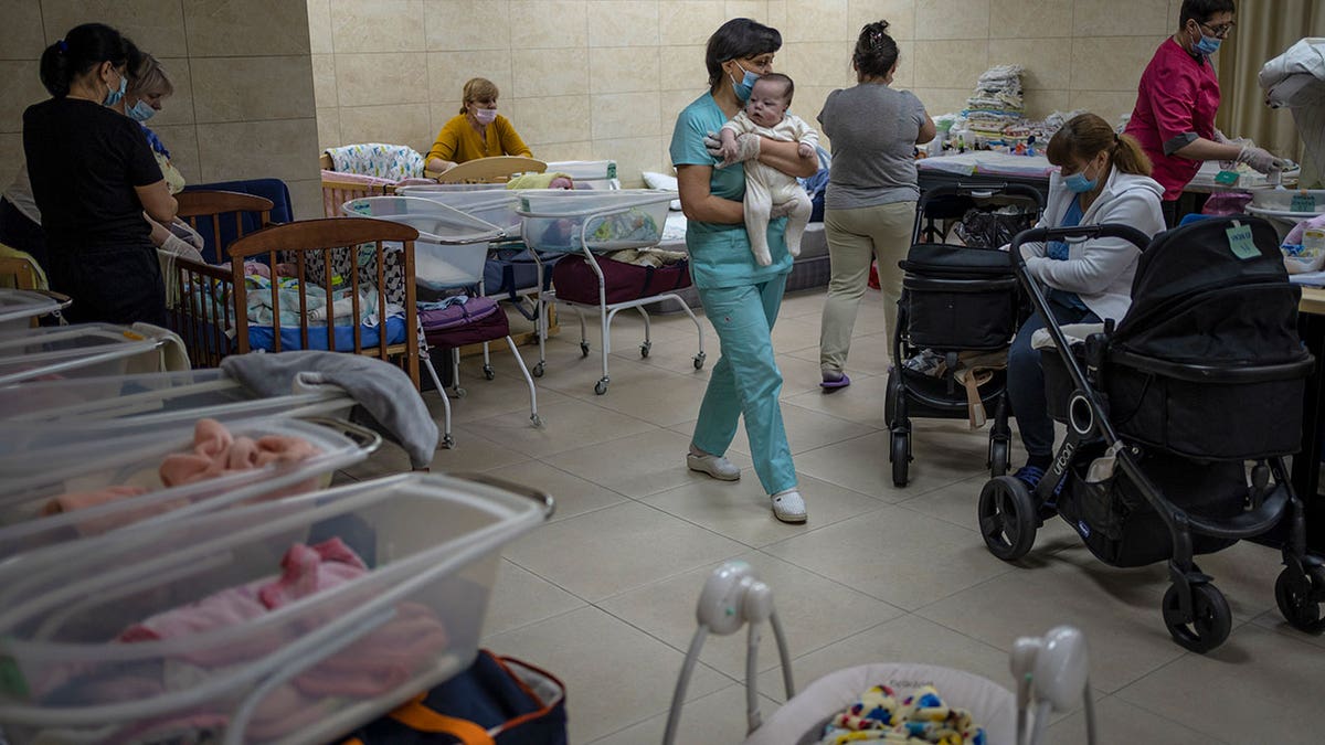 Nannies take care of newborn babies in a basement converted into a nursery in Kyiv, Ukraine, Saturday, March 19, 2022. 