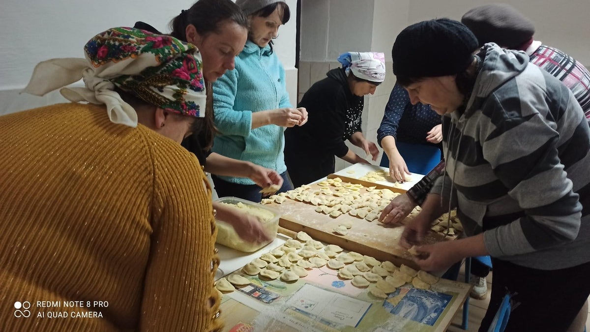 women in village Ukraine making potato dumplings for Ukraine forces