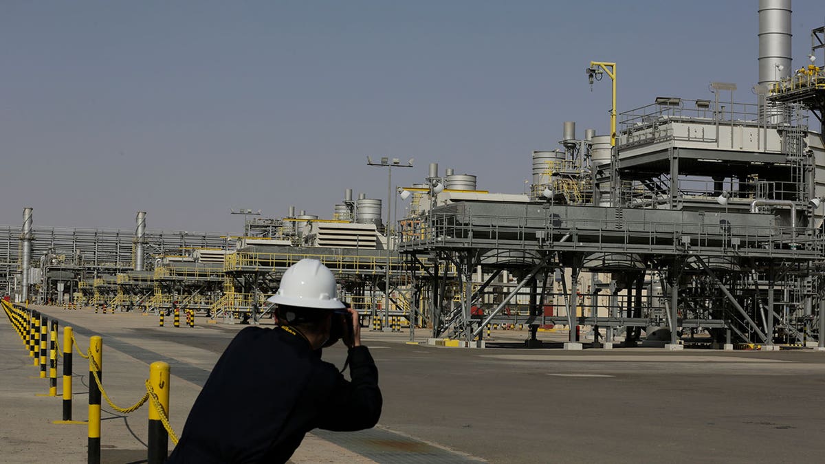A photographer takes pictures of the Khurais oil field during a tour for journalists, 150 km east-northeast of Riyadh, Saudi Arabia, June 28, 2021.