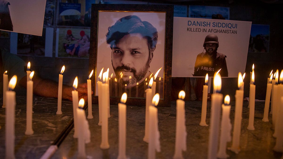 In this July 17, 2021, file photo, journalists in New Delhi, India, light candles and pay tribute to Reuters photographer Danish Siddiqui, who was killed in Afghanistan covering clashes between the Taliban and Afghan security forces. 