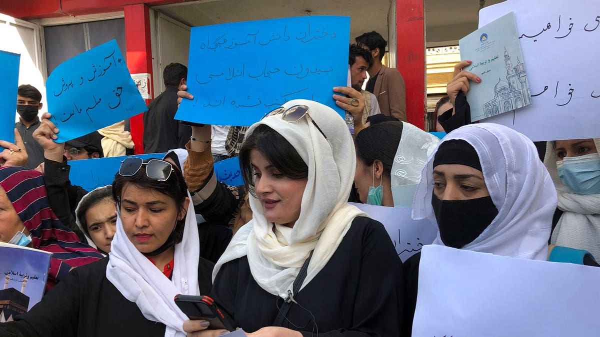 Afghan women chant and hold signs to protest during a demonstration in Kabul, Afghanistan, Saturday, March 26, 2022. Afghanistan's Taliban rulers refused to allow dozens of women to board several flights, including some overseas, because they were traveling without a male guardian, two Afghan airline officials said Saturday.