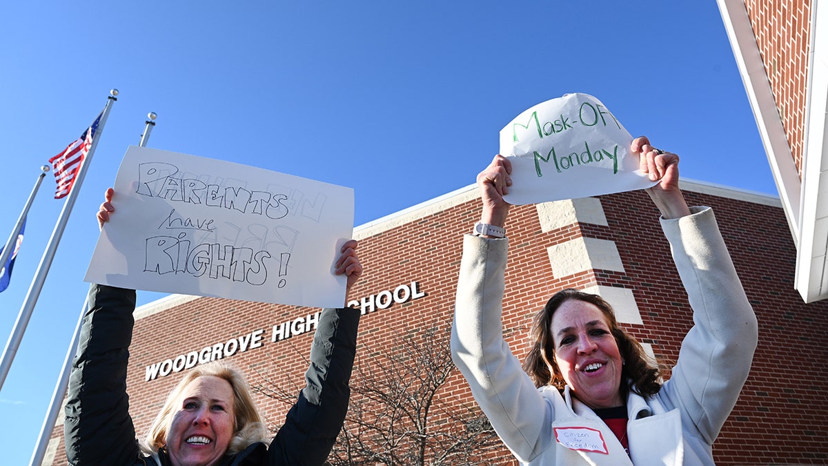 Jean Ballard, left, and Heather West, join about two dozen parents gathered outside Woodgrove High School in an anti mask protest January 24, 2022 in Purcellville, VA.