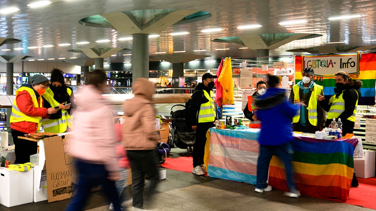 Volunteers waiting for refugees from Ukraine stand at information desks at the main train station in Berlin, Germany, Tuesday, March 15, 2022. 