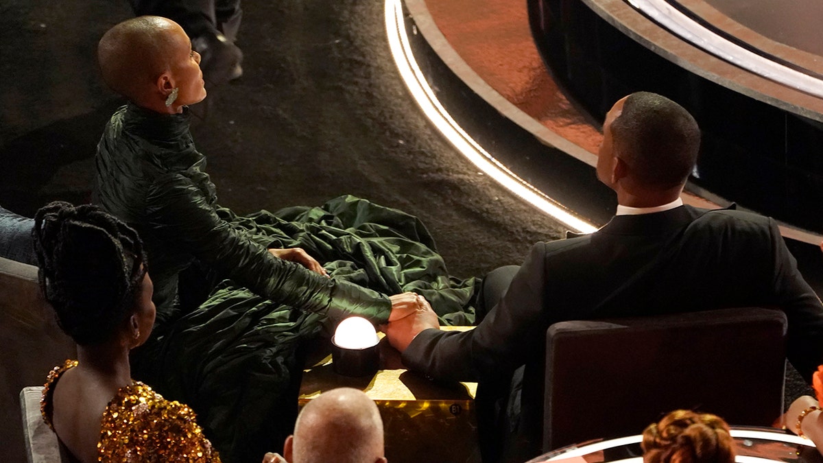 Jada Pinkett Smith, left, and Will Smith hold hands in the audience at the Oscars on Sunday, March 27, 2022, at the Dolby Theatre in Los Angeles.?