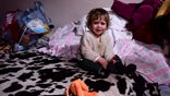 A child sits on a bed in a room hosted by the local Free Christian Church, for those fleeing Ukraine, in the village of Uszka, Hungary, Thursday, March 3, 2022.