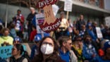 Holly Thorsta, foreground, an art teacher at Roosevelt High, stands in silence with other teachers as Native American leaders honored the land in front of the Davis Center to picket on the 10th day of the teachers strike in Minneapolis, Monday, March 21, 2022. (Jerry Holt/Star Tribune via AP)