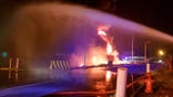 In this photo provided by the Saudi Press Agency, firefighters try to extinguish a blaze at an Aramco terminal in the southern border town of Jizan, Saudi Arabia, early Sunday, March 20, 2022. Yemen’s Houthi rebels unleashed a barrage of drone and missile strikes on Saudi Arabia early Sunday that targeted a liquified natural gas plant, water desalination plant, oil facility and power station, Saudi state-run media reported. (Saudi Press Agency via AP)