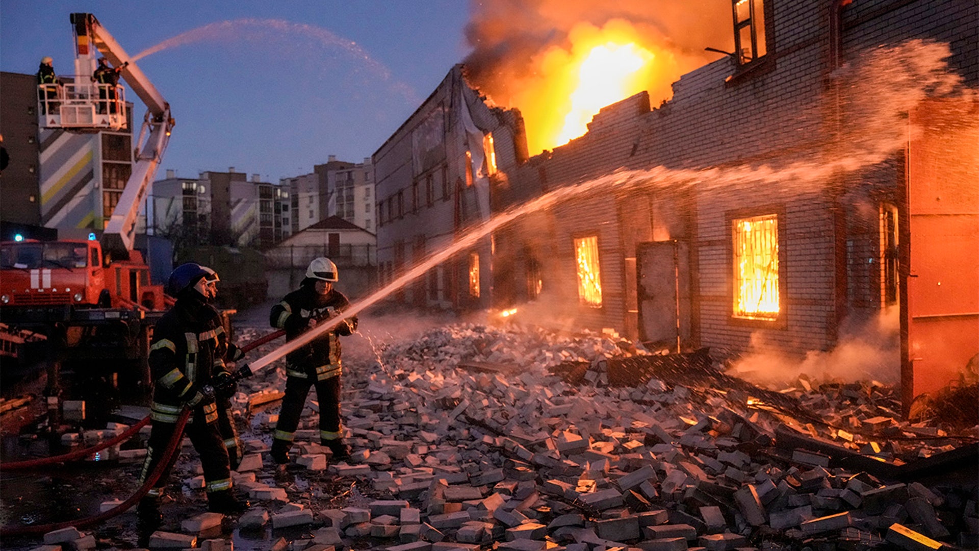 Ukrainian firefighters extinguish a blaze at a warehouse after a bombing in Kyiv, Ukraine, Thursday, March 17, 2022.