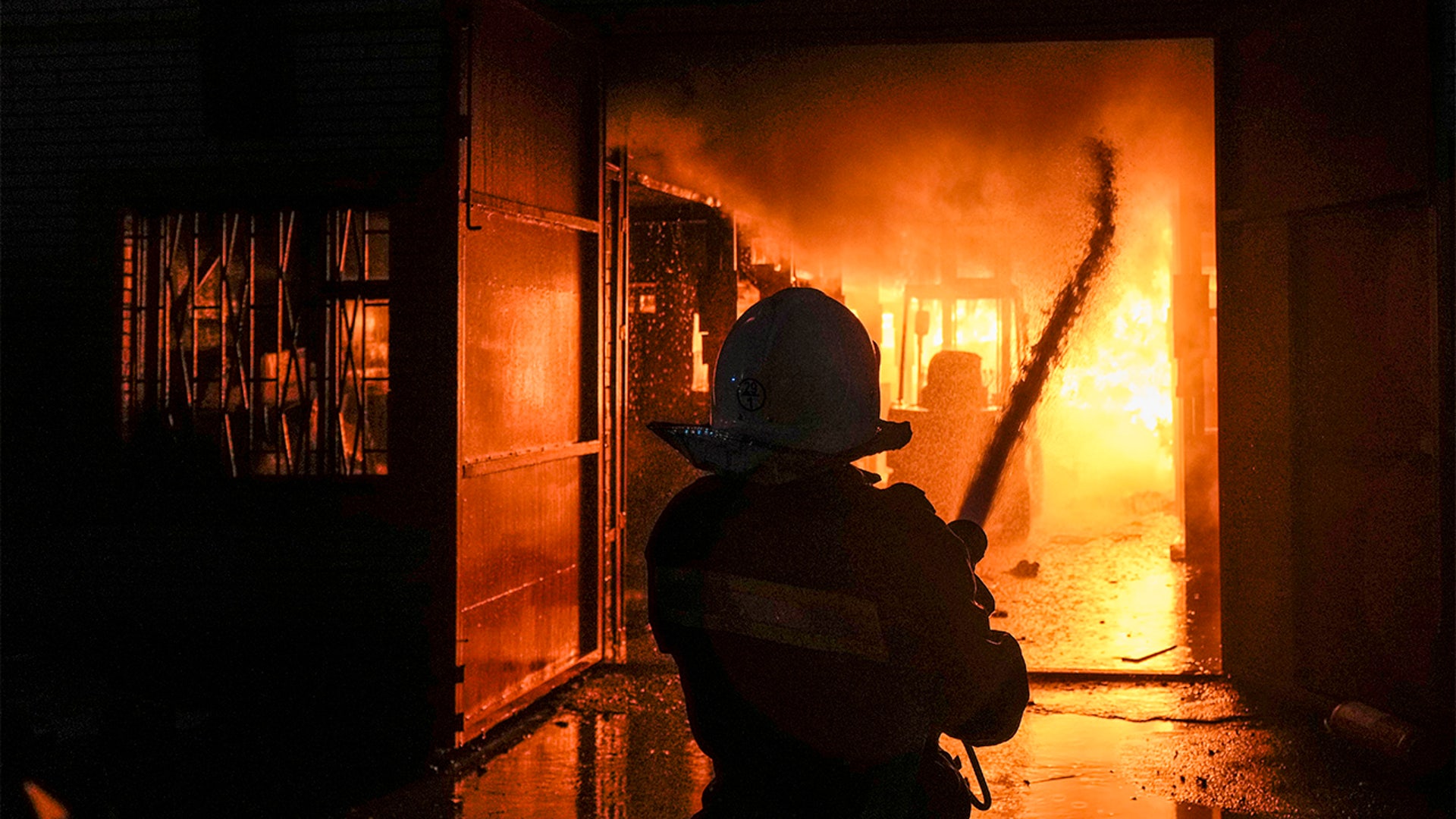 Ukrainian firefighters extinguish a blaze at a warehouse after a bombing in Kyiv, Ukraine, Thursday, March 17, 2022.