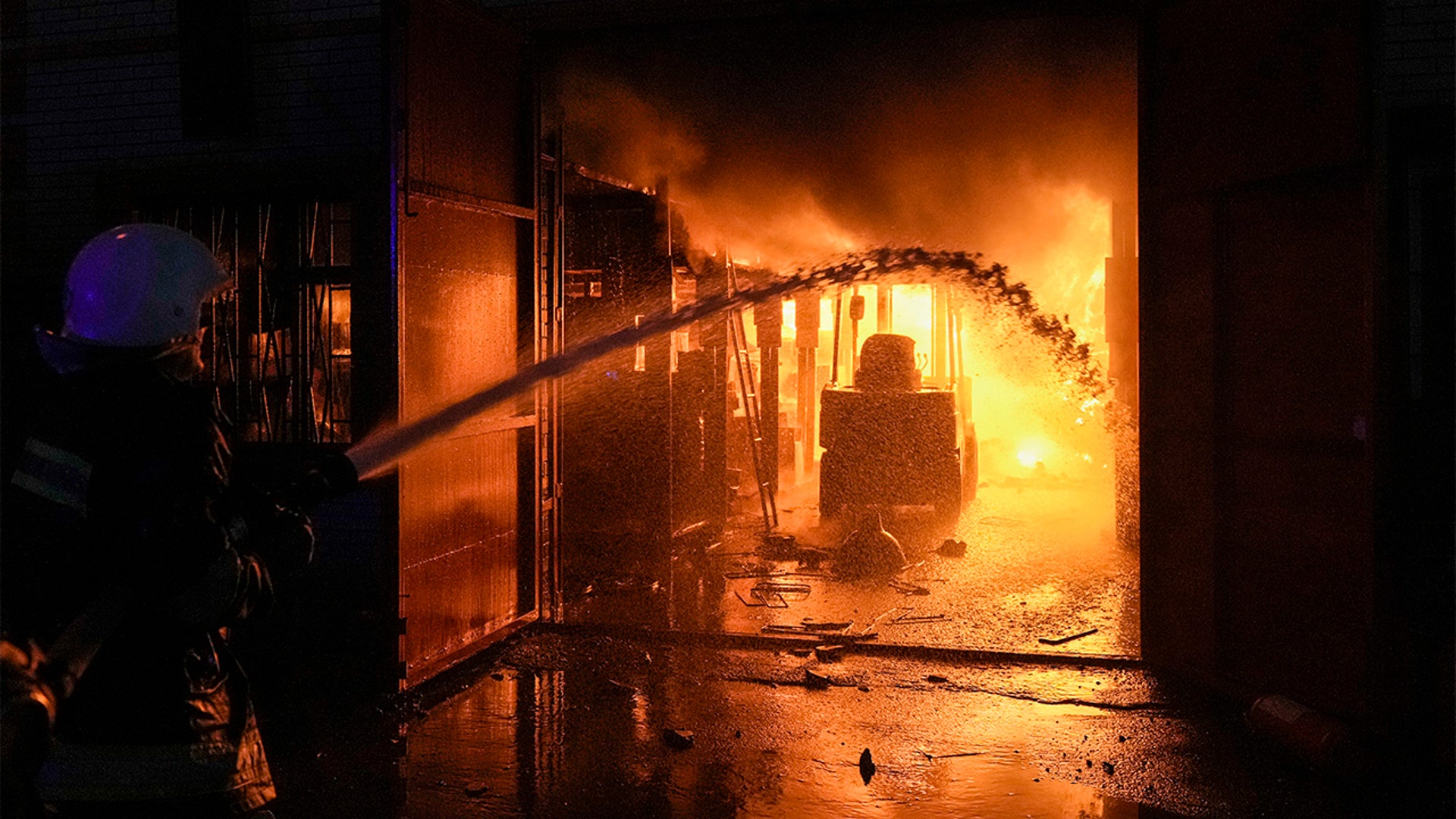 Ukrainian firefighters extinguish a blaze at a warehouse after a bombing in Kyiv, Ukraine, Thursday, March 17, 2022.