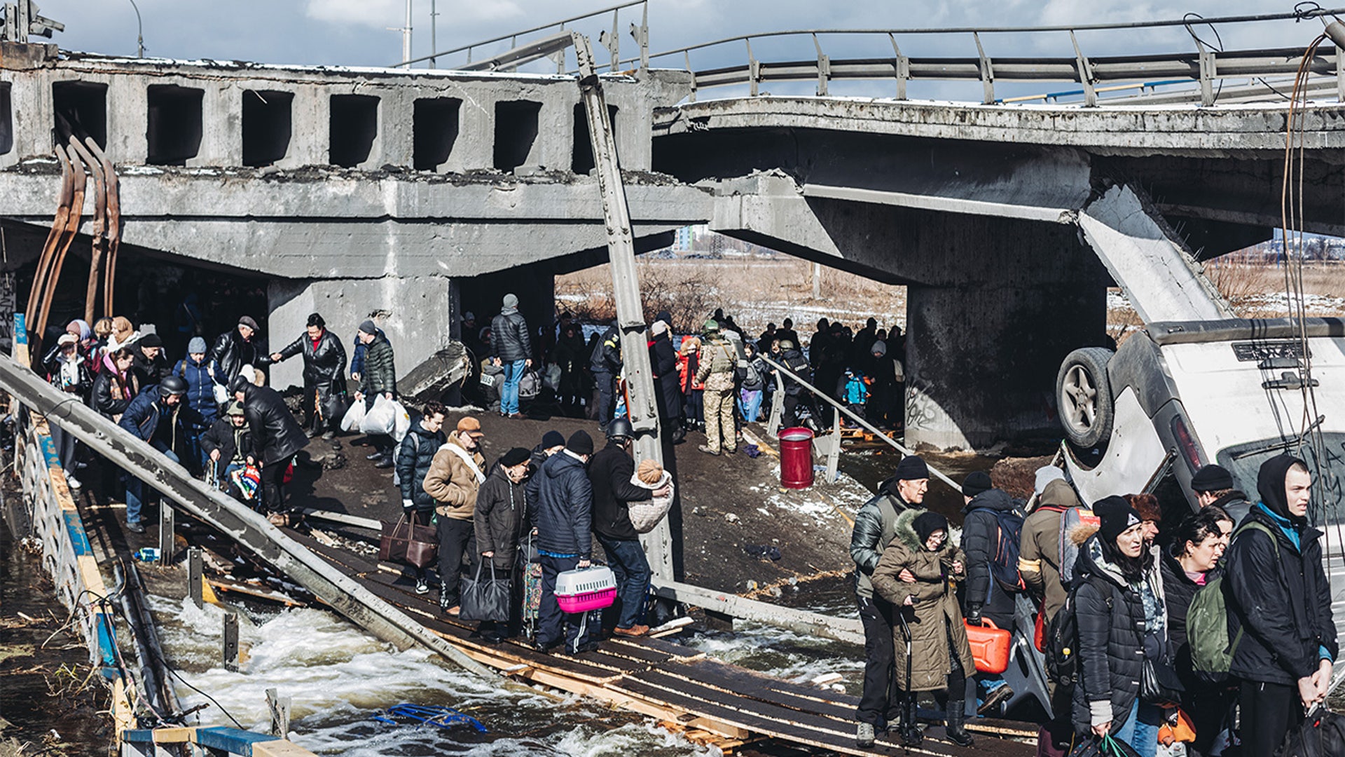 A large number of people cross the destroyed bridge as civilians continue to flee from Irpin due to ongoing Russian attacks in Irpin, Ukraine on March 08, 2022.