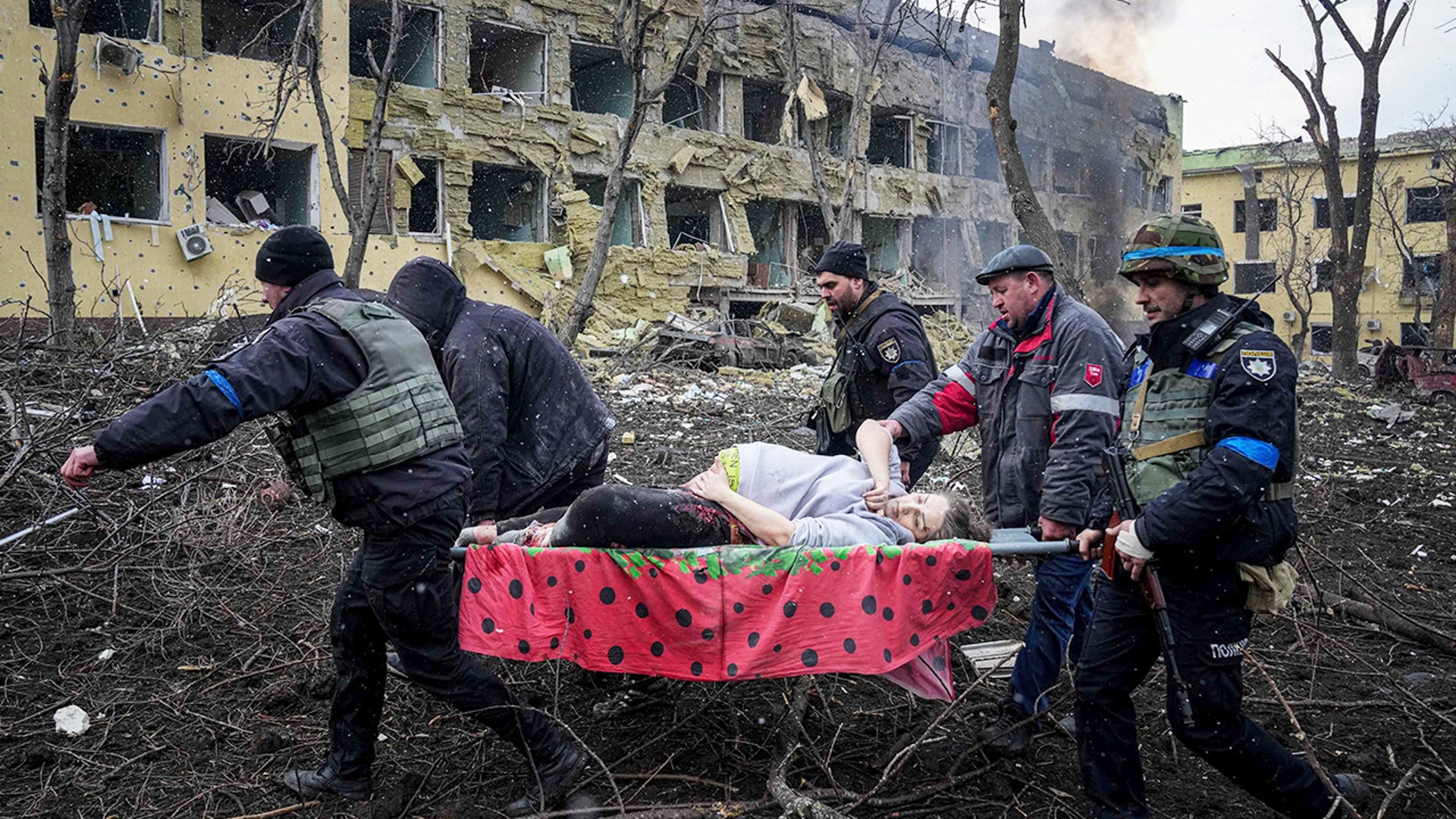 Ukrainian emergency employees and volunteers carry an injured pregnant woman from the damaged by shelling maternity hospital in Mariupol, Ukraine, Wednesday, March 9, 2022. A Russian attack has severely damaged a maternity hospital in the besieged port city of Mariupol, Ukrainian officials say.