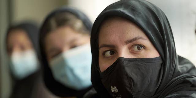 Afghan refugee Mozhgan Entazari, right, talks about the challenge to find proper housing for her family in Southern California, during an interview at a hotel lobby in Irvine, Calif., Tuesday, Feb. 15, 2022.