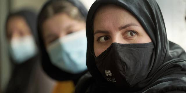 Afghan refugee Mozhgan Entazari, right, talks about the challenge to find proper housing for her family in Southern California, during an interview at a hotel lobby in Irvine, Calif., Tuesday, Feb. 15, 2022.