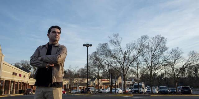 Afghan refugee Ahmad Saeed Totakhail poses for a photograph at a shopping center near his home in Dale City, Va.