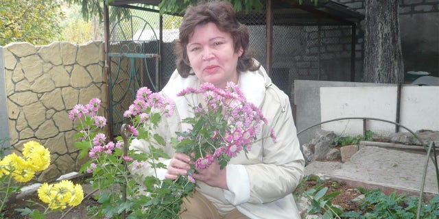 Matthew Frantsuzhan's grandmother, Galina, holds flowers in the garden of her home in Ukraine. He said his grandmothers will not leave their native land. "They have spent their lives there," he told Fox News Digital.