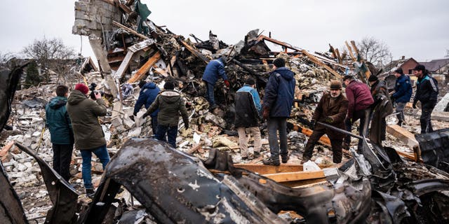 Local residents work among remains of a residential building destroyed by shelling as Russia's invasion of Ukraine continues in Zhytomyr, Ukraine, March 2, 2022.