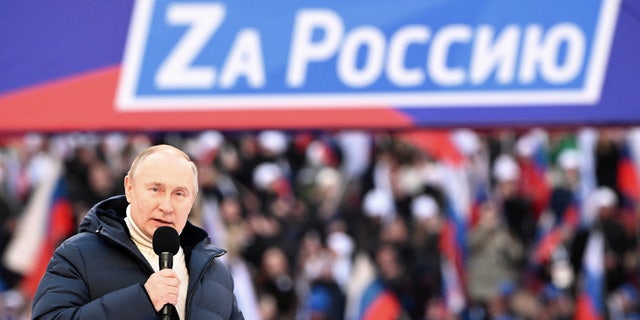 Russian President Vladimir Putin delivers a speech during a concert marking the eighth anniversary of Russia's annexation of Crimea at Luzhniki Stadium in Moscow, Russia, March 18, 2022. The banner reads: "For Russia". 