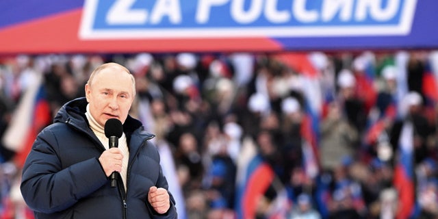 Russian President Vladimir Putin delivers a speech during a concert marking the eighth anniversary of Russia's annexation of Crimea at Luzhniki Stadium in Moscow, Russia March 18, 2022. The banner reads: "For Russia".