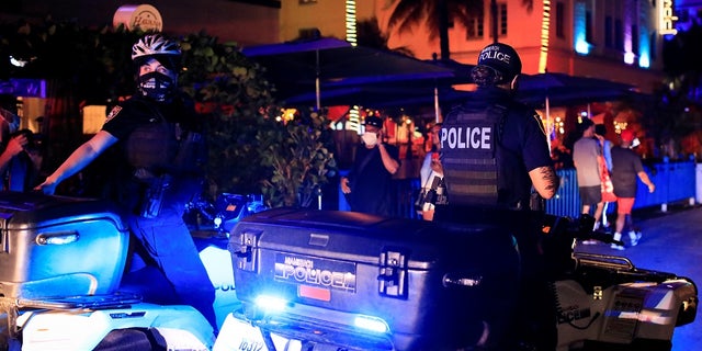 Miami Beach police officers enforce an 8 p.m. curfew imposed by local authorities on spring break festivities, amid the coronavirus disease (COVID-19) pandemic, in Miami Beach, Florida, U.S., March 26, 2021. REUTERS/Marco Bello