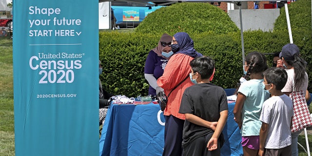 People stand in line at a Census 2020 booth at a farmer's market in Everett, MA on July 24, 2020.