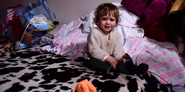 A child sits on a bed in a room hosted by the local Free Christian Church, for those fleeing Ukraine, in the village of Uszka, Hungary, on March 3, 2022.