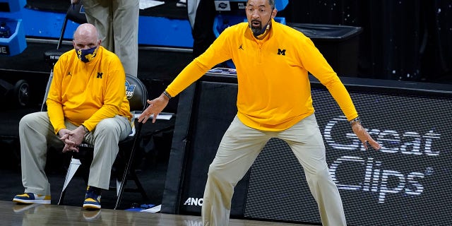 文件 - Michigan head coach Juwan Howard reacts to a play as associate head coach Phil Martelli watches from the bench during the first half of the team's Elite Eight game against UCLA in the NCAA men's college basketball tournament March 30, 2021, in Indianapolis. Martelli will fill in for Howard for the rest of the regular season. Howard was suspended five games and fined $ 40,000 by the Big Ten Conference after hitting a Wisconsin assistant coach in the head during the handshake line after a loss Sunday, 二月. 20.