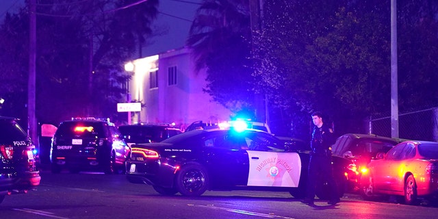 Law enforcement vehicles from several agencies block a street near the scene of a shooting in Sacramento, Calif., Monday, Feb. 28, 2022.